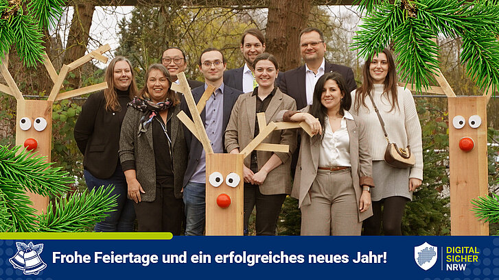 Das Team von DIGITAL.SICHER.NRW steht neben Pfeilern, die wie Rentiere aussehen.