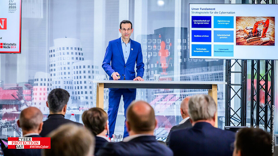 Referent vor einem Tisch auf der Bühne vom Wiwo Cyberprotection Day 2026