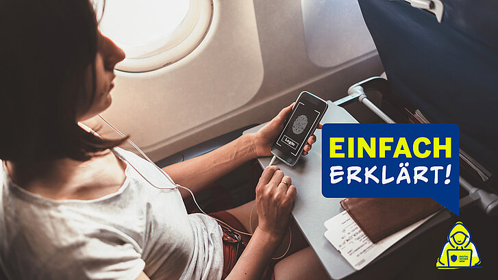 Eine Frau sitzt in einem Flugzeug und hält in ihrer Hand ein Smartphone